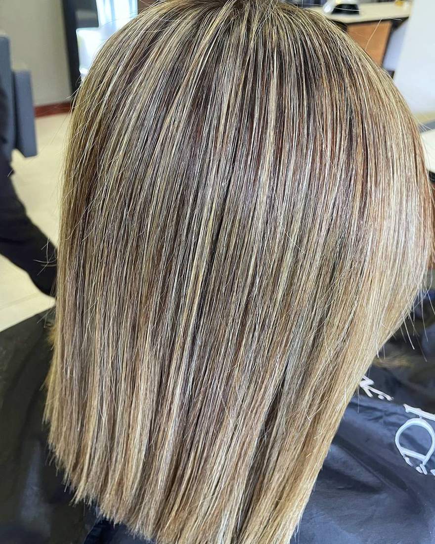 Mechas rubio ceniza sobre long bob liso, iluminación a mano alzada en Quito